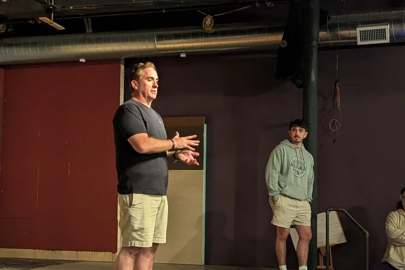 A Phoenix Collective director working with a student on stage