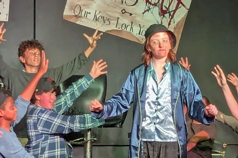 Cast of Oliver! The Musical on stage in front of an audience