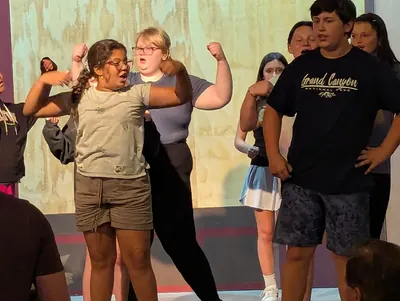 Students improvising together with their arms raised